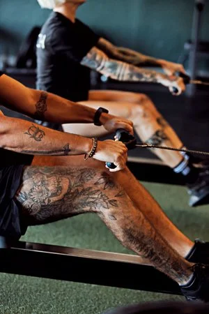 People working out on rowing machines in a gym.