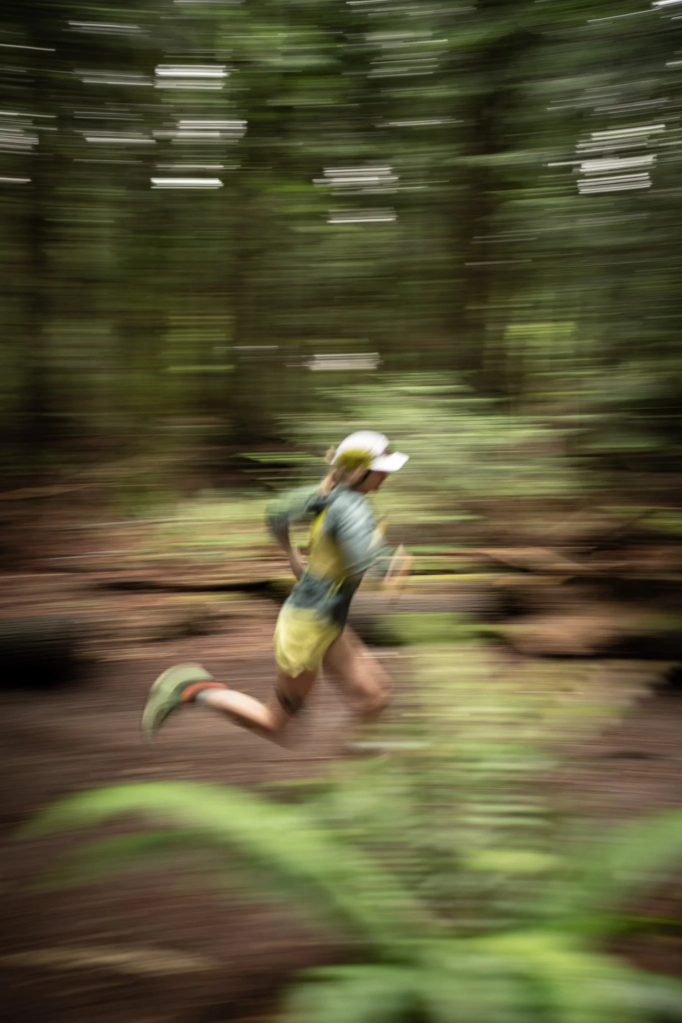 A person running in a forest, with a blurred background indicating motion.