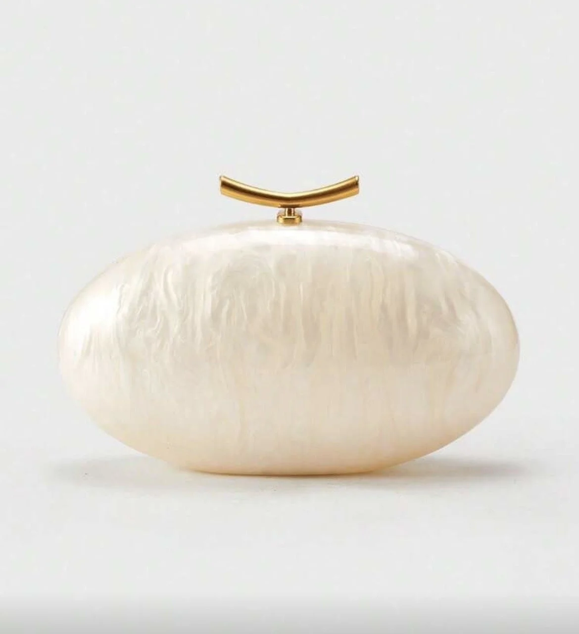 Elegant clutch purse with a pearlescent finish and a gold curved handle on top, photographed against a plain white background.