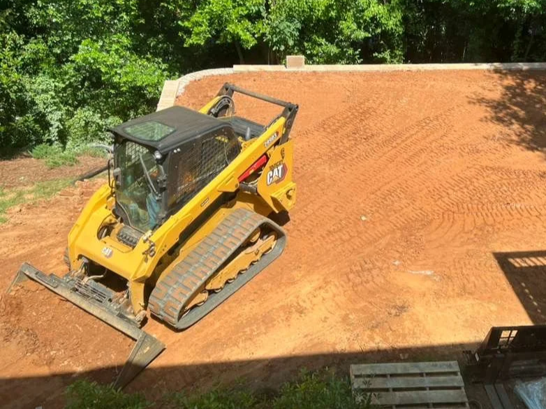 bobcat and tractor performing landscaping duties