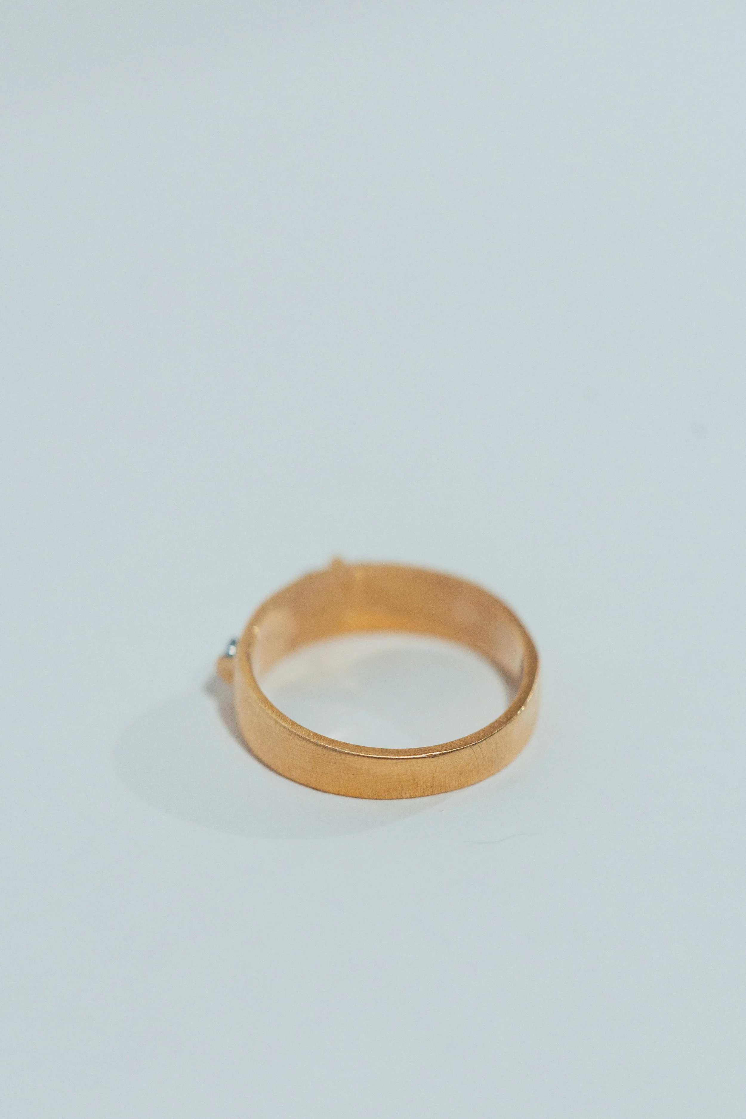 Gold ring placed on a white surface