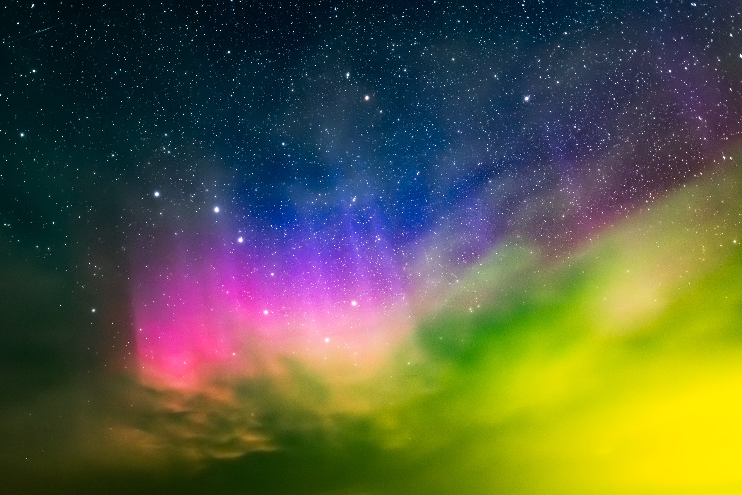 Colorful night sky with stars and aurora borealis with shades of pink, purple, blue, and green.