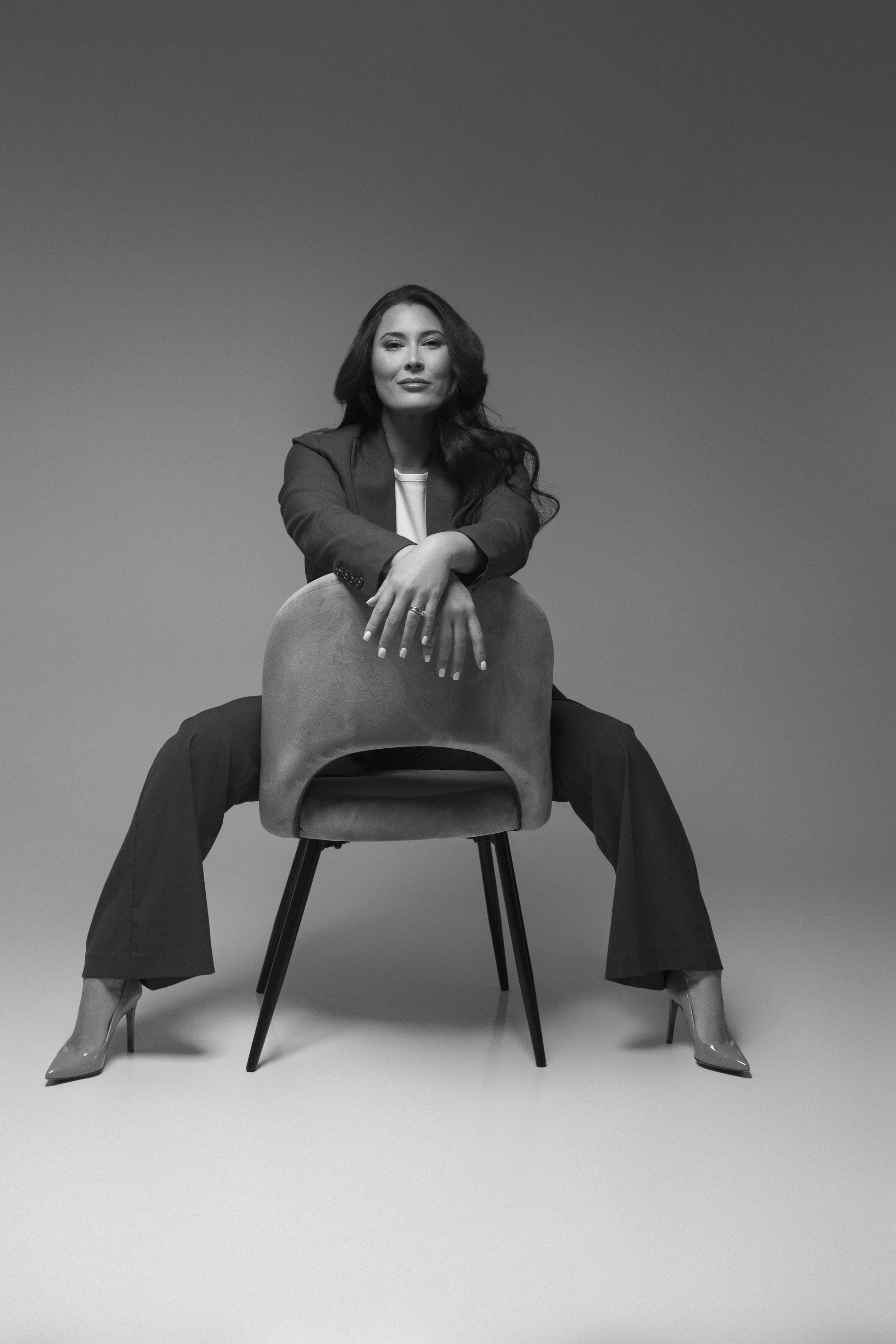 Woman entrepreneur sharing her brand story in a dramatically lit studio portrait.