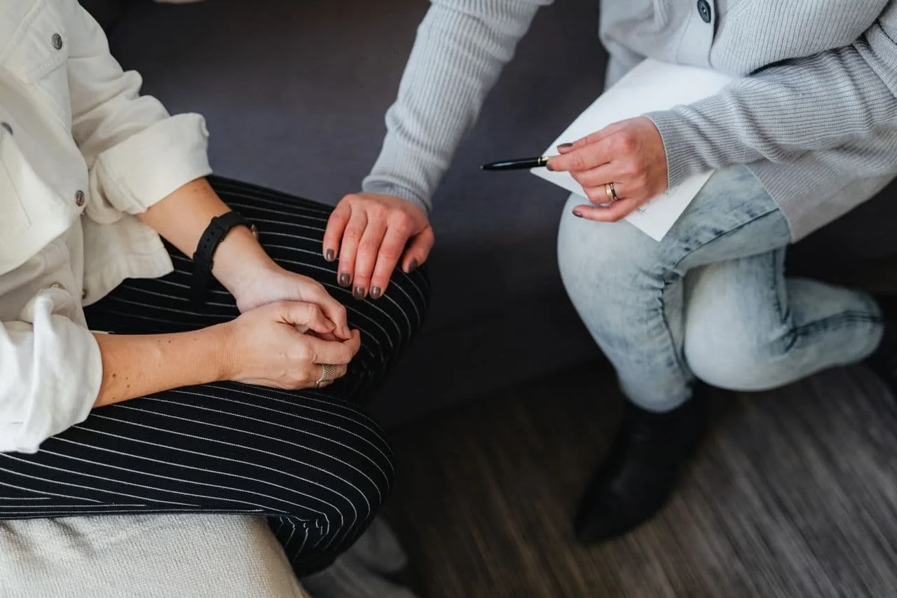 person-in-gray-jacket-touching-a-person-s-knee
