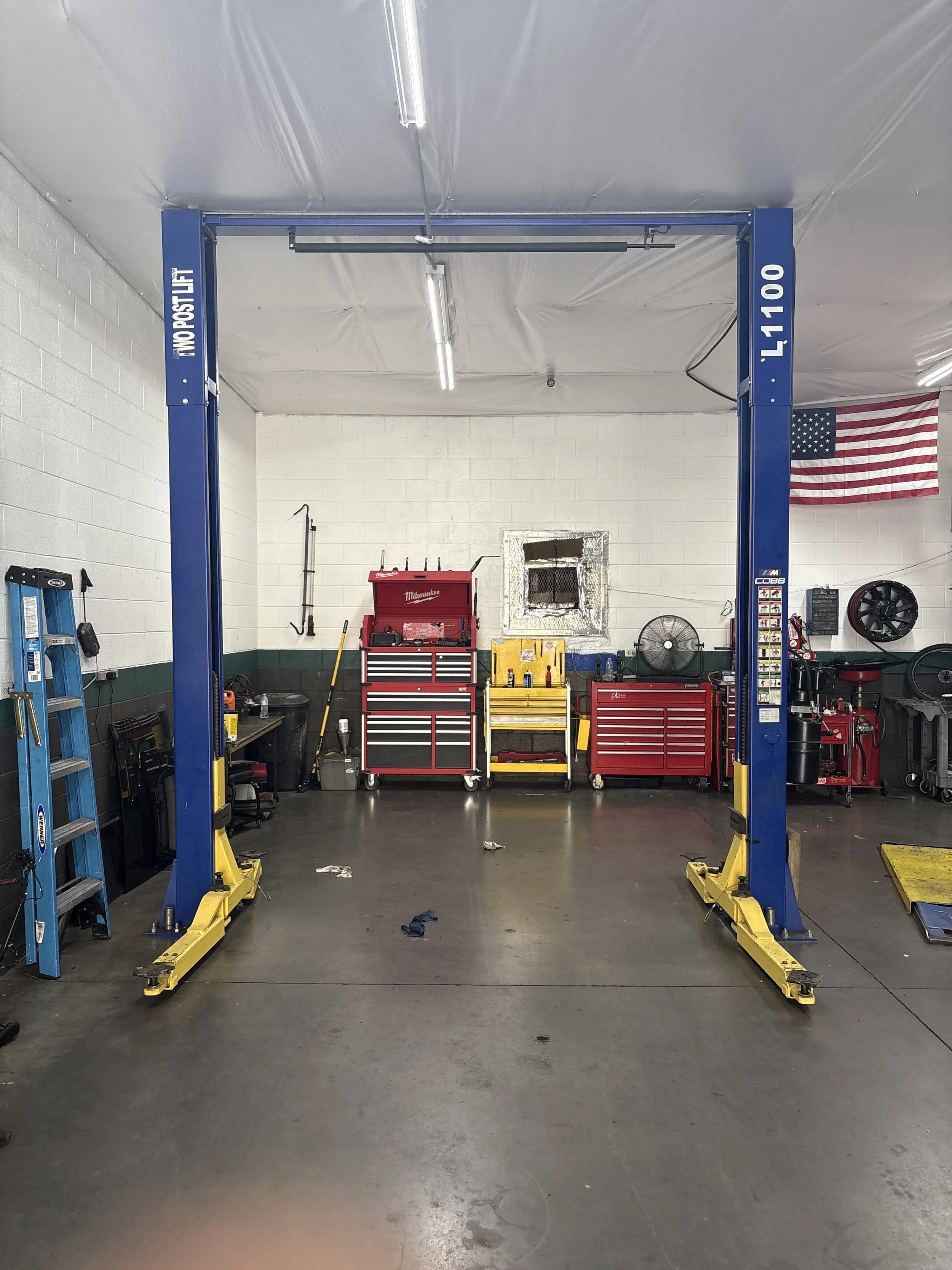 Interior of GDL Auto Electric and Mechanic. Showcasing tools, two post lifts. and workbench for auto repair and diagnostics