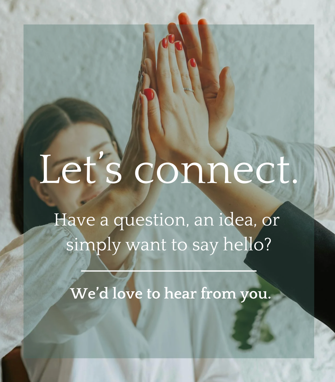 Two people high-fiving each other. One person with painted nails and a ring, another person in a blazer. Background is a plain wall.