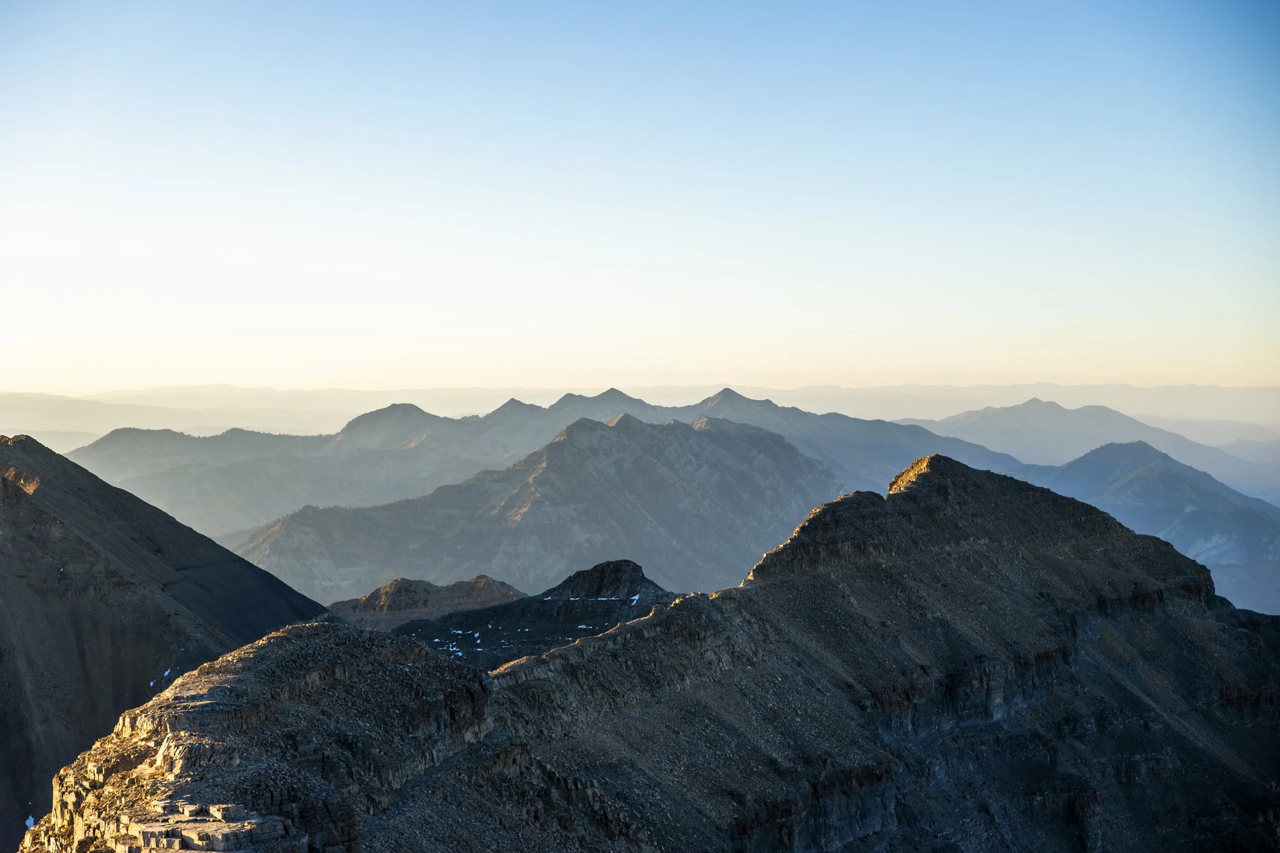 Scenic view of mountain range during sunset with layers of peaks fading into the distance.