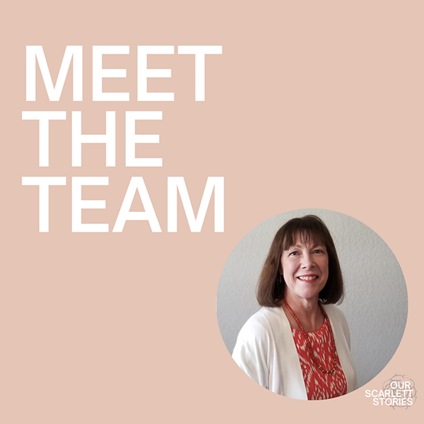A woman with shoulder-length brown hair wearing a white cardigan and a red patterned blouse smiling against a gray wall, with a pink background that says 'Meet the Team' and a small logo that reads 'Our Scarlet Stories'.