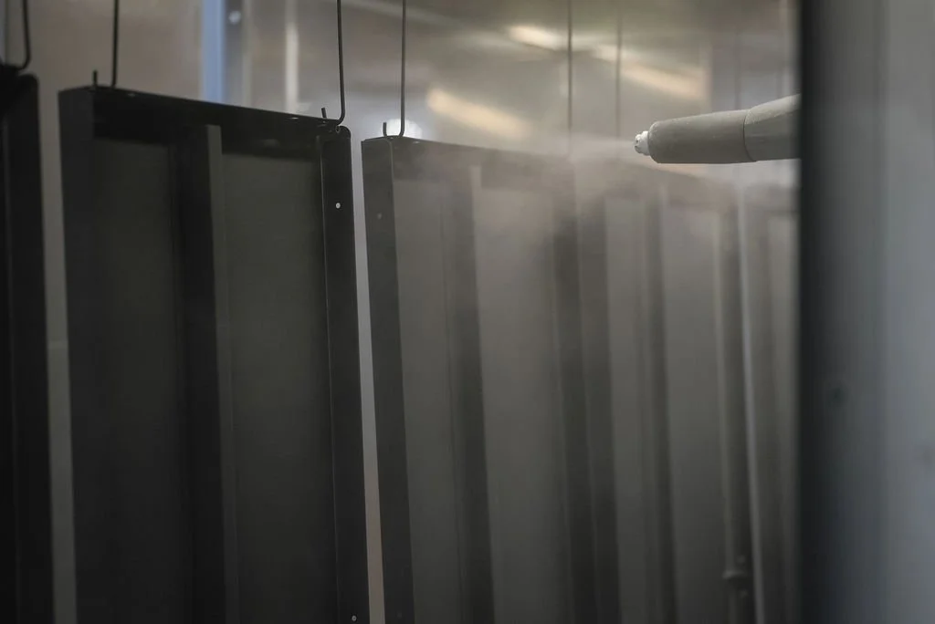 A fogging machine fogging a row of metal lockers or cabinets.