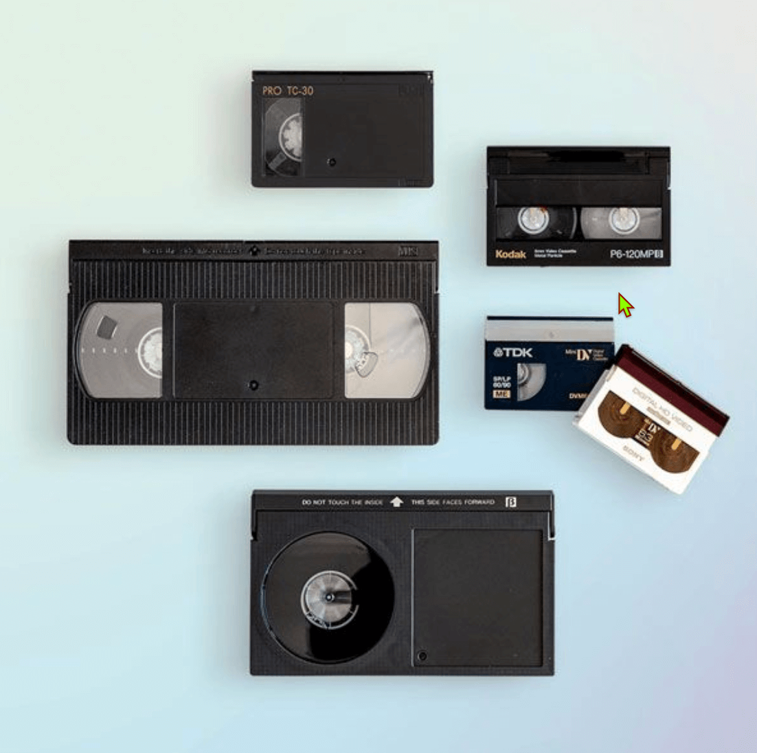 Photo of assorted video tape formats including VHS, MiniDV, Hi8, Digital8, Betamax, and compact camcorder tapes, representing video transfer and digitization services.