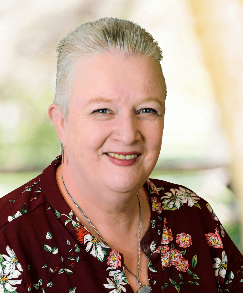 Professional headshot of Melody Helmick, Certified Photo Manager and owner of AP Photo Solutions, smiling in a floral top with a soft green background.