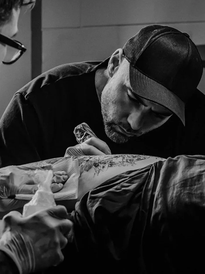 Ryan Evans tattoo artist working on a client's arm