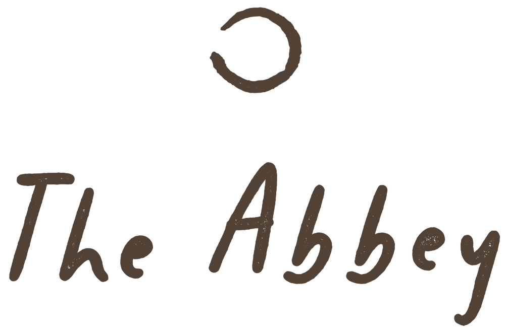 Logo for The Abbey with a stylized circular emblem above the text.