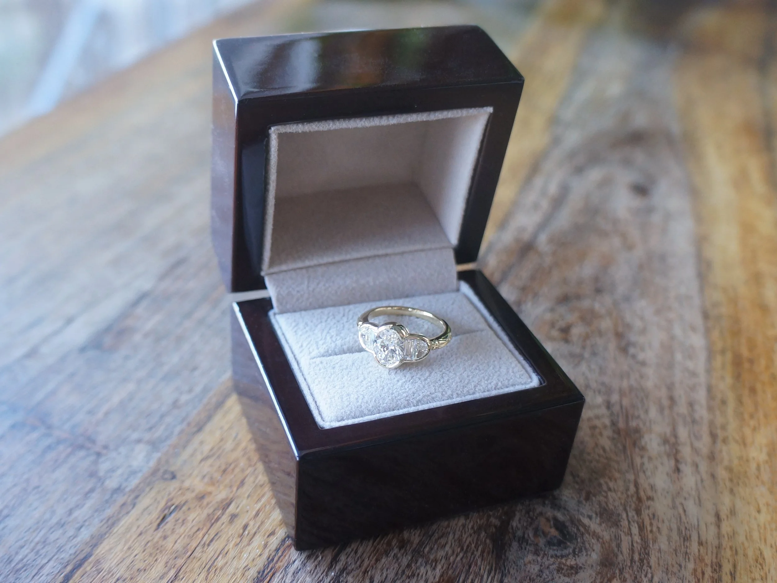 A finished custom lab grown diamond engagement ring in a presentation box.