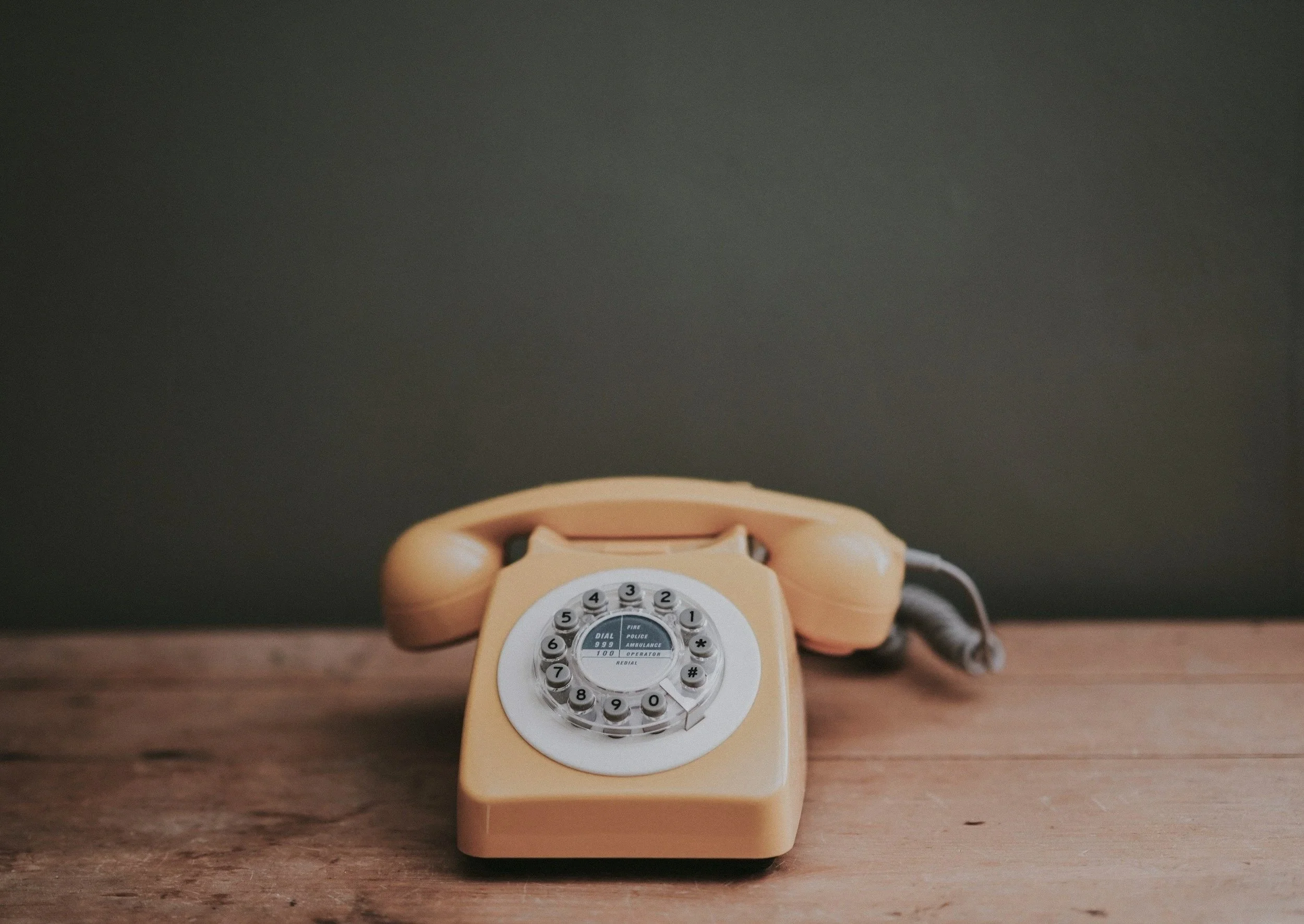 Vintage rotary telephone on a desk symbolizing personal, reliable communication and approachability