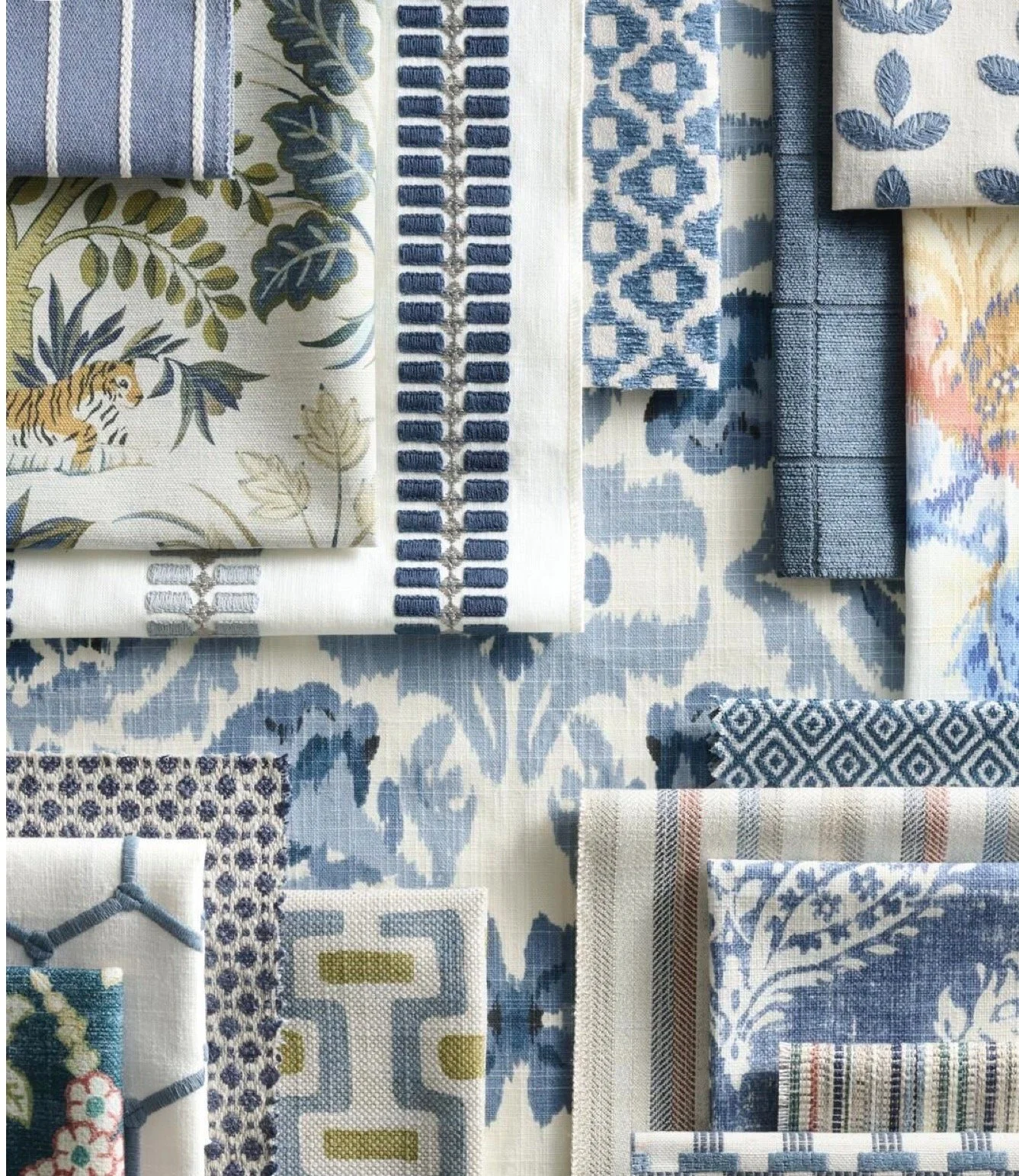 A collection of fabric swatches in various shades of blue, white, and some with green accents, featuring different patterns including stripes, florals, geometric shapes, and animal print.