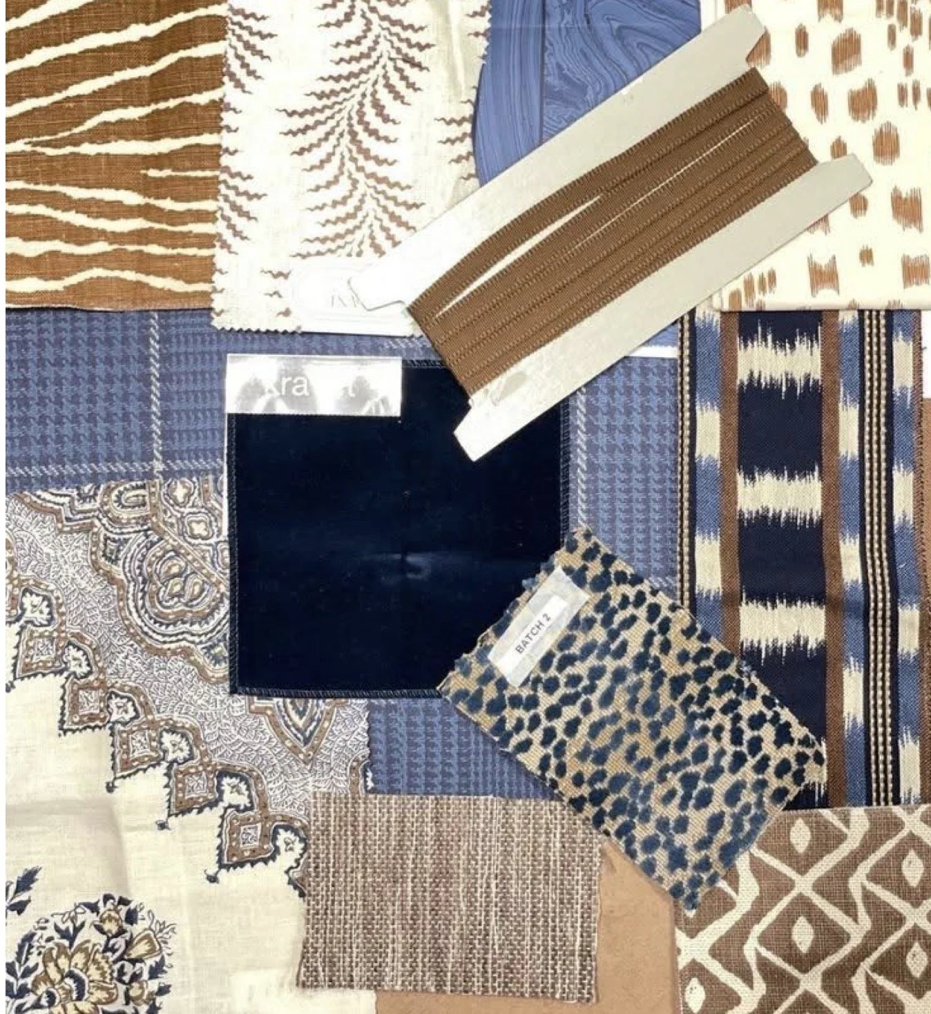 Display of various fabric swatches in different patterns and colors including animal prints, geometric designs, and solid colors, arranged together on a flat surface.