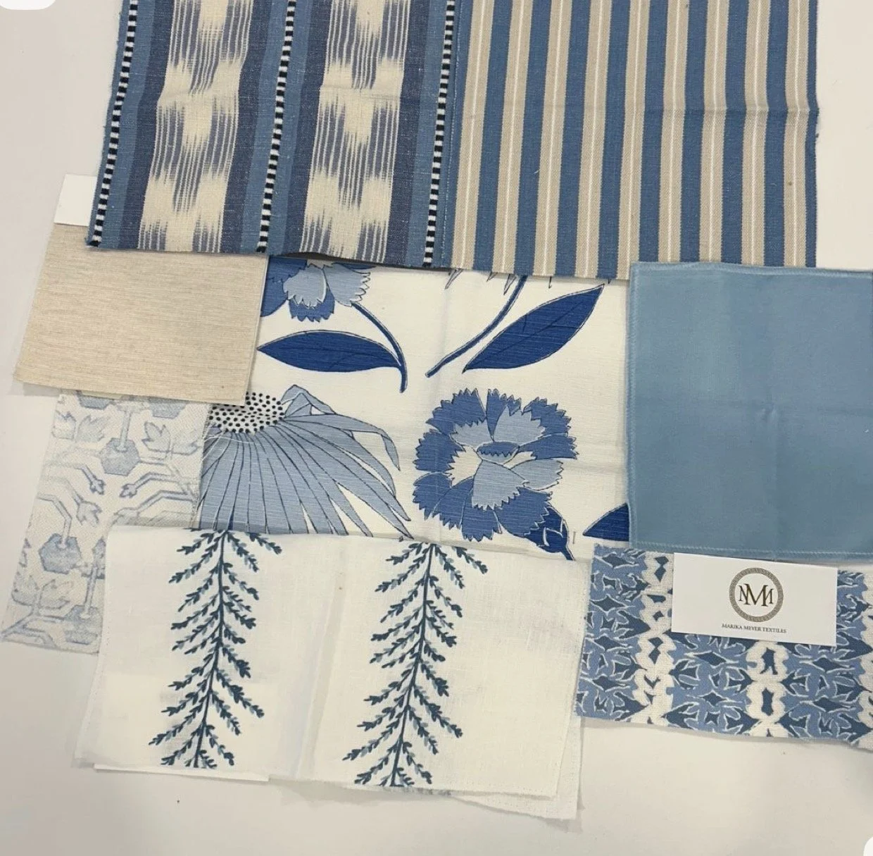Sample fabric swatches in shades of blue and beige, with patterns including floral, stripes, and geometric designs.