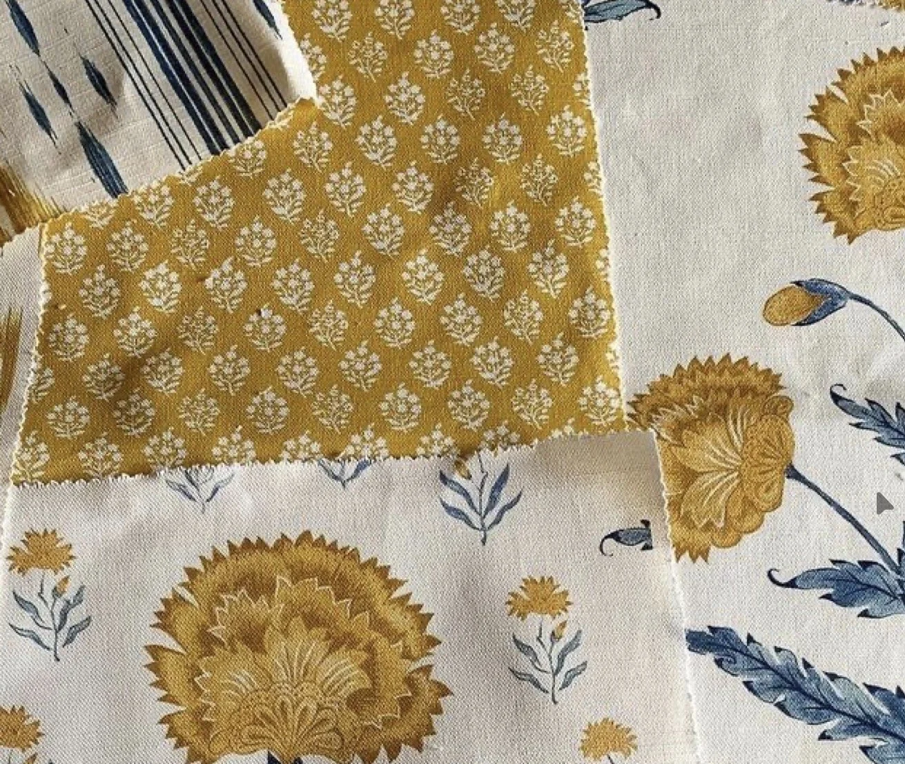 Close-up of fabric samples with floral and geometric patterns in yellow, white, and blue colors.