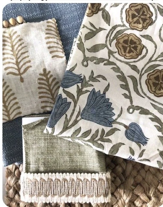 Close-up of decorative fabric and textiles with floral and leaf patterns in neutral tones, placed on a woven surface.