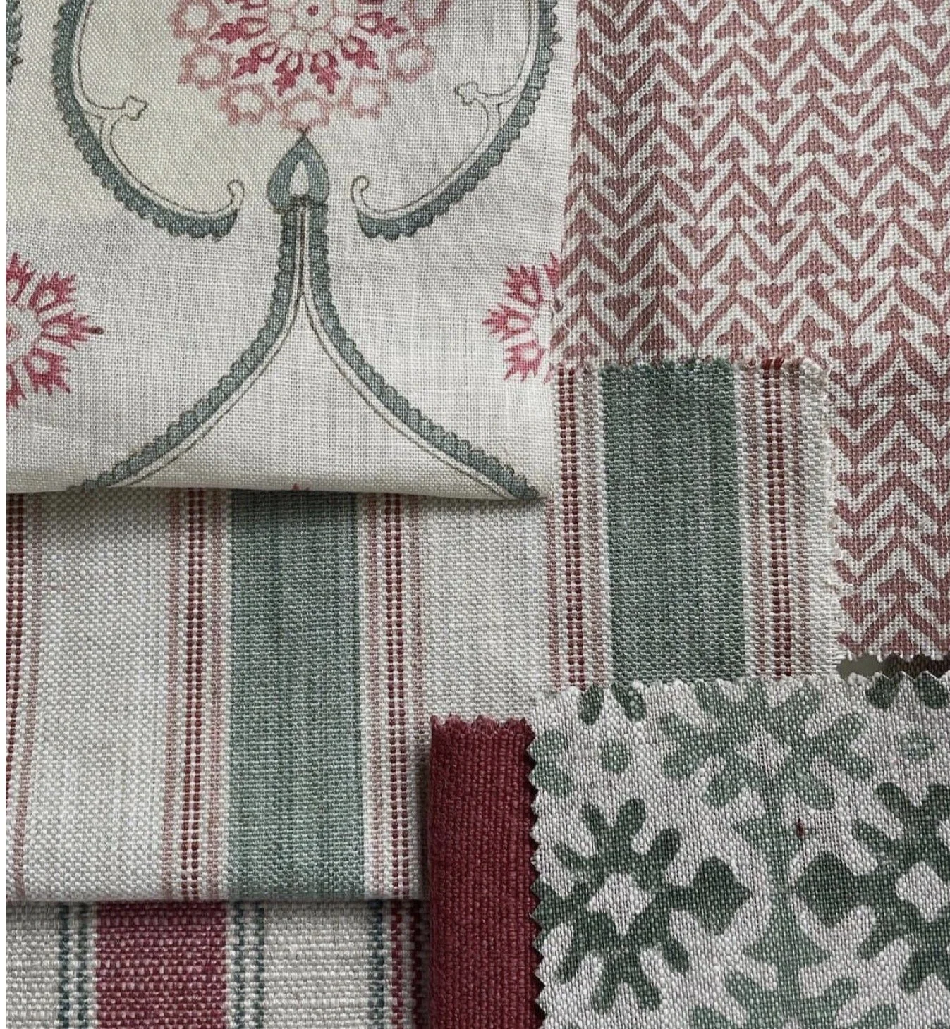 Close-up of various patterned fabric swatches in red, white, and green colors, including stripes, geometric, and floral designs.