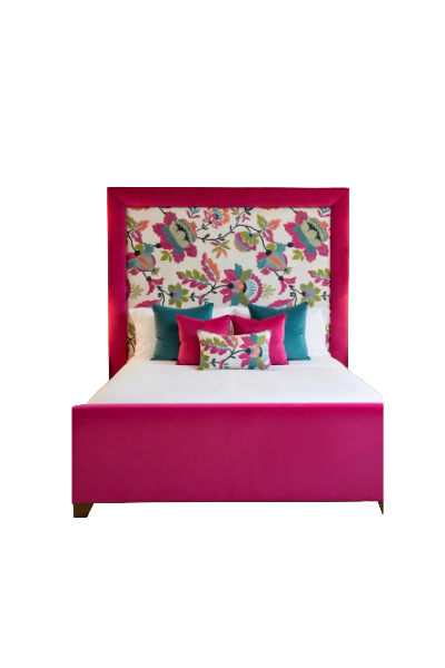Pink bed with multicolored floral patterned headboard, white bedding, and decorative pillows in teal, pink, and floral patterns.