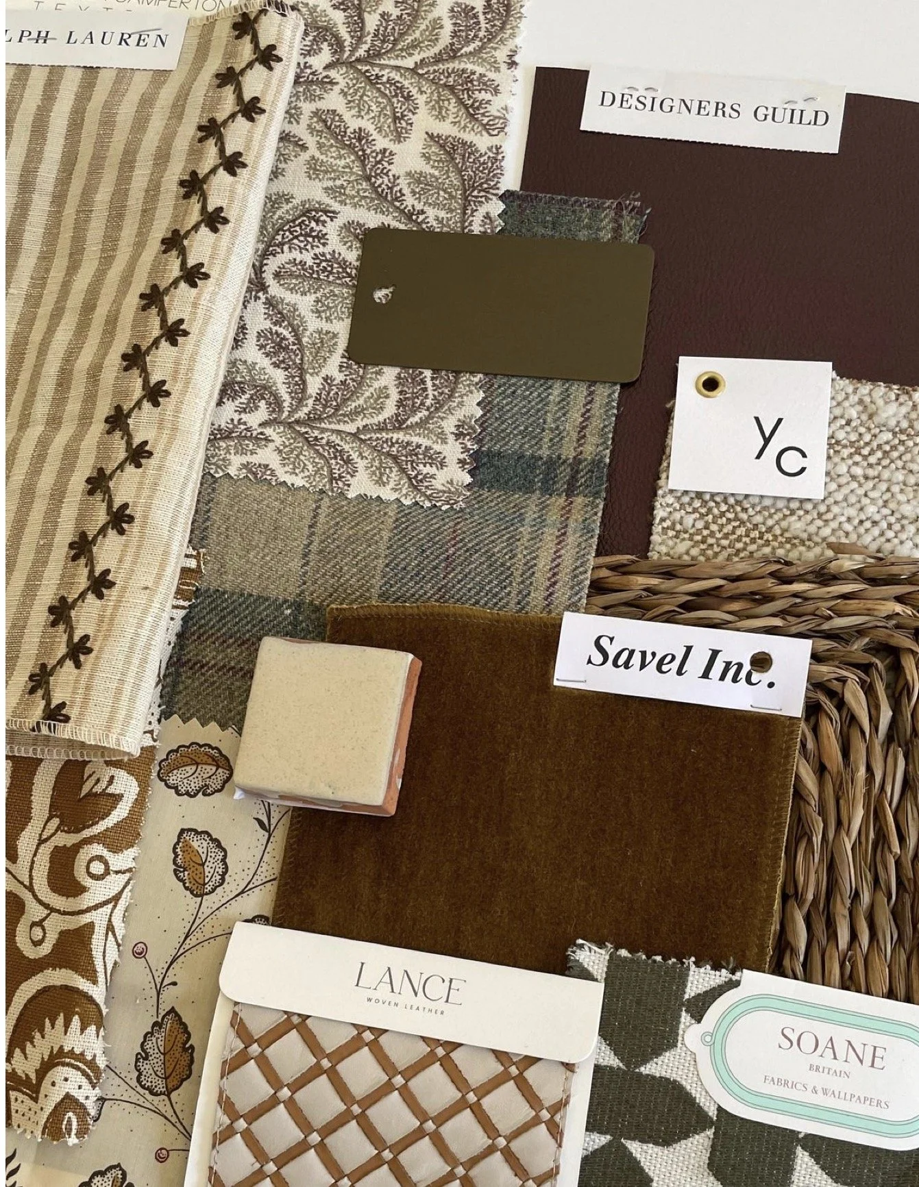 Fabric samples in various patterns and colors, some with labels. A wicker basket and tags with text such as 'Yc,' 'Savel Inc.,' and 'Lance woven leather' are visible.