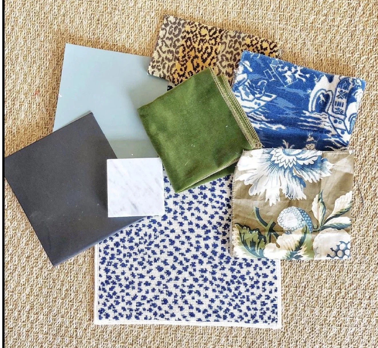 A collection of six fabric swatches in various colors and patterns, including leopard print, blue and white, green, floral, and black and white, arranged on a textured beige surface.