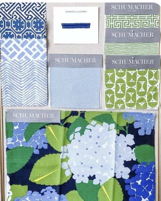 Collection of fabric swatches in various shades of blue, green, and white with geometric and floral patterns, and a small box labeled 'SAMUEL & SONS.'