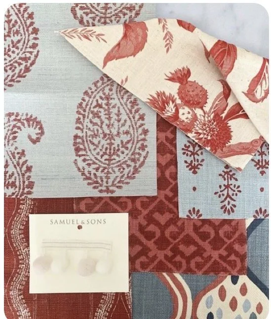 A collection of fabric swatches with red, cream, and blue patterns, including floral and geometric designs, and a small piece of matching fabric with a tree branch motif, along with a note card from Samuel & Sons.