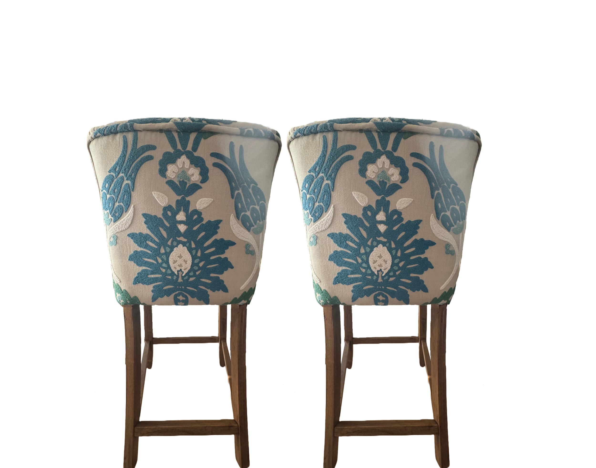 Two upholstered bar stools with wooden legs, featuring a blue and white floral pattern on the fabric.
