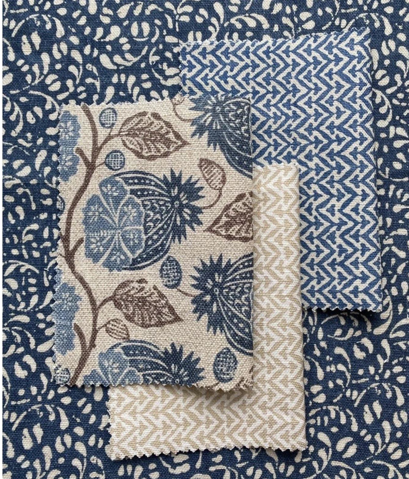 Three fabric swatches with different floral and geometric patterns layered on top of each other.