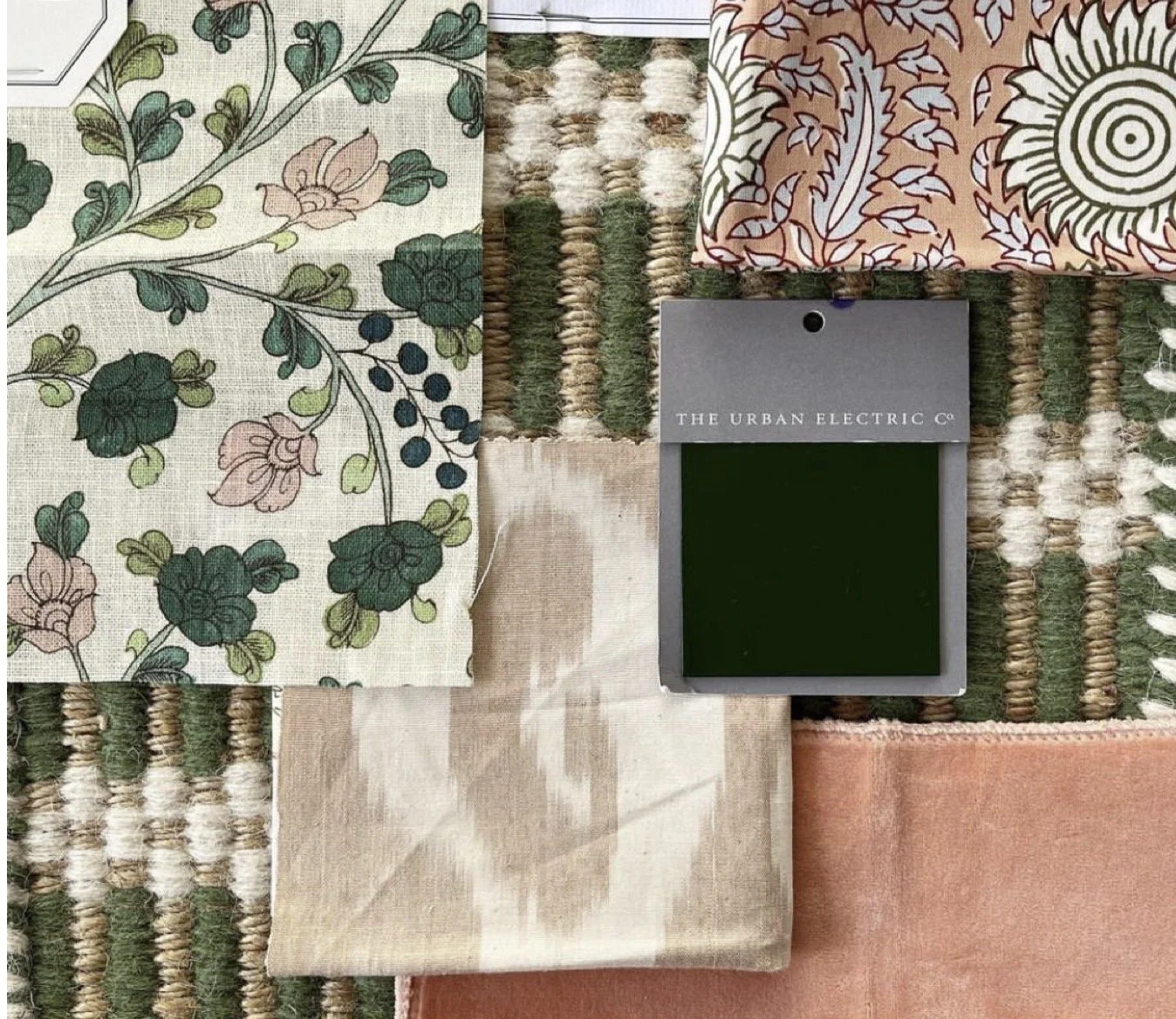 Various fabric swatches with textures and patterns, including floral, abstract, and solid colors, along with a sample color card from The Urban Electric Co.