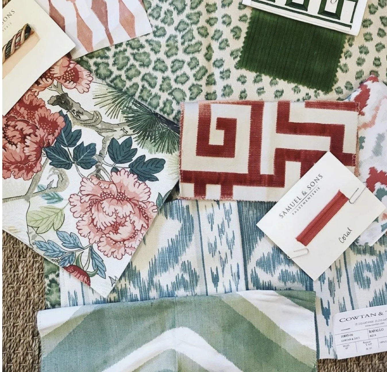 A collection of fabric swatches with various patterns and colors, including floral, geometric, and abstract designs, laid out on a surface.