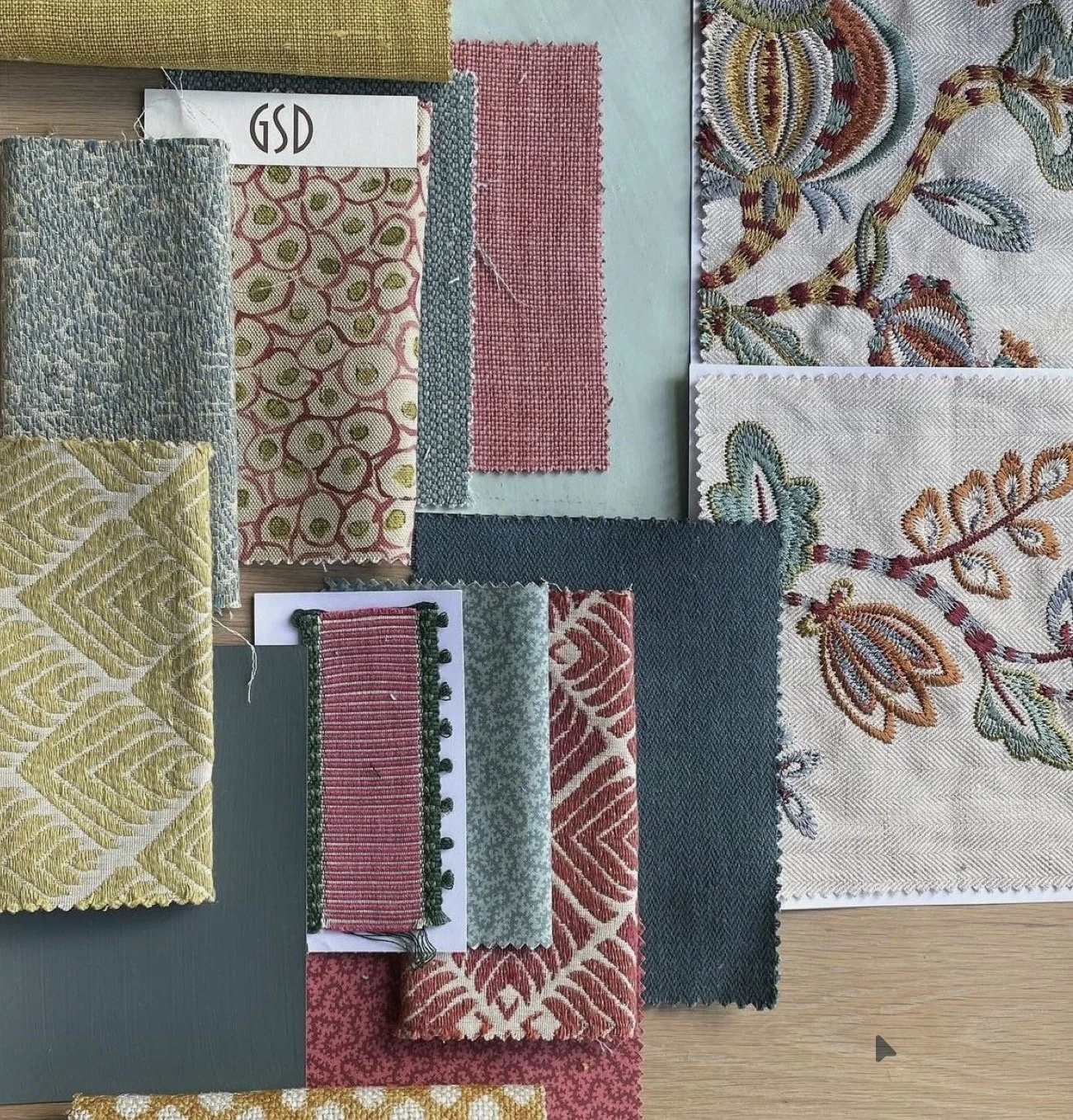 A variety of fabric swatches with different patterns and colors, arranged on a surface.
