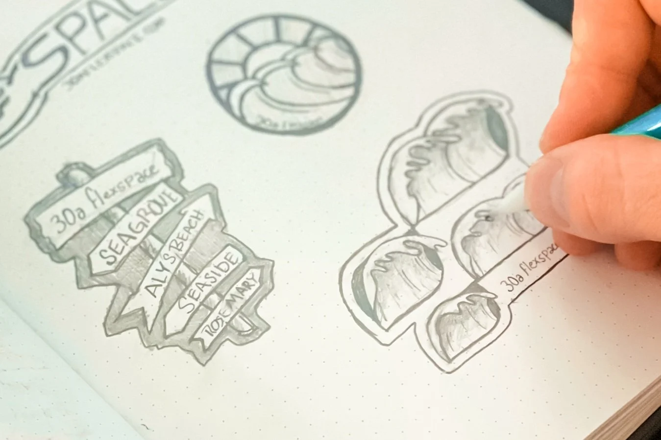 Hand sketching a logo or label design for Seagrape with the text '30a Florida' and decorative elements.