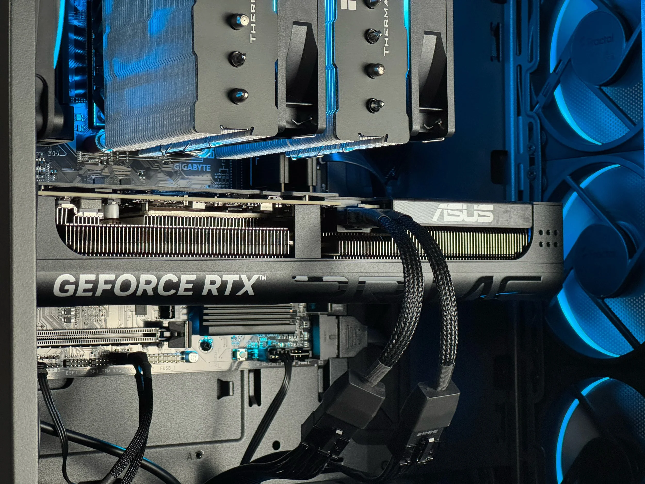 An image of an ASUS PRIME RTX 5070 housed inside the Zenith Z3. Motherboard, Air Cooler, and case fans seen in the background.