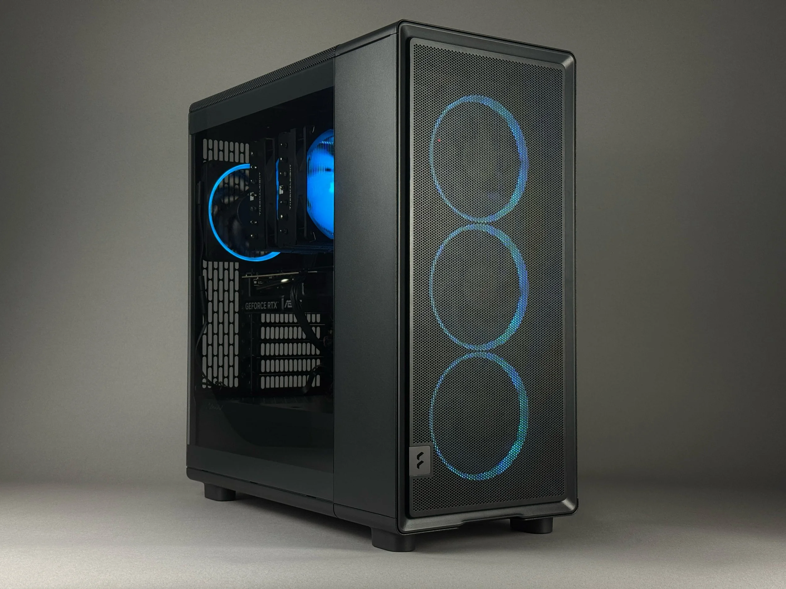 Zenith Z3 gaming PC in a Fractal Epoch case with ARGB Fans and a tempered glass side panel showing internal components. Internal view shows GeForce RTX 5070, Thermalright Phantom Spirit CPU cooler with RGB.