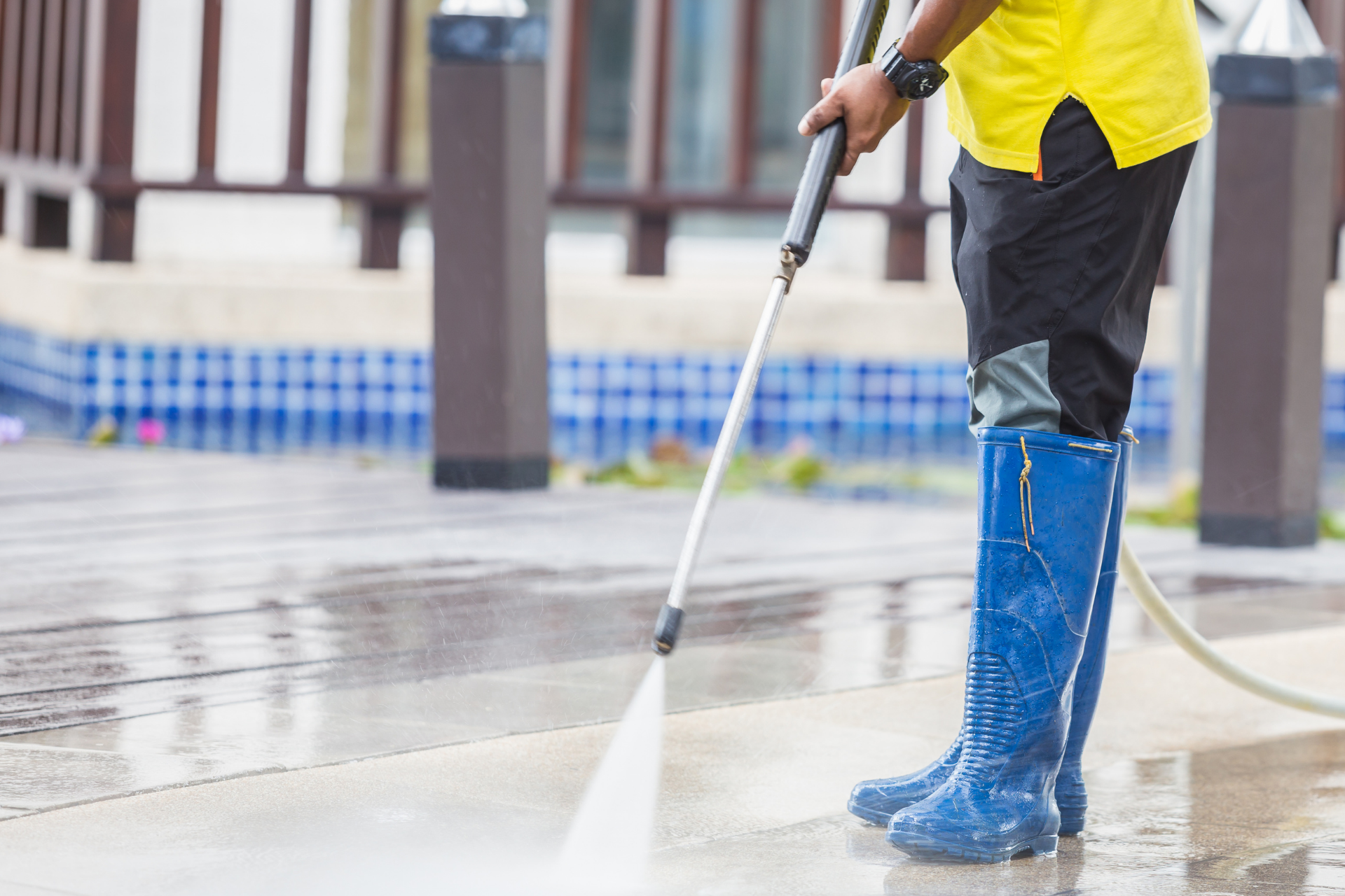 Man pressure washing concrete
