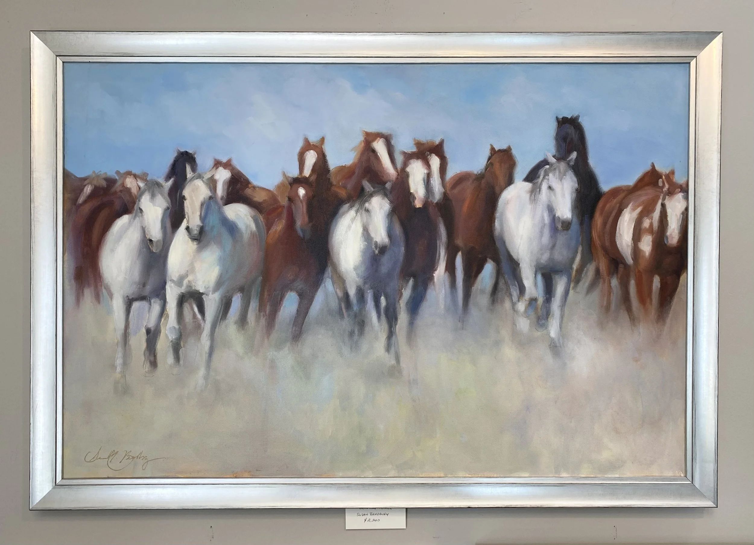 Painting of a herd of horses running through a dusty field under a blue sky.