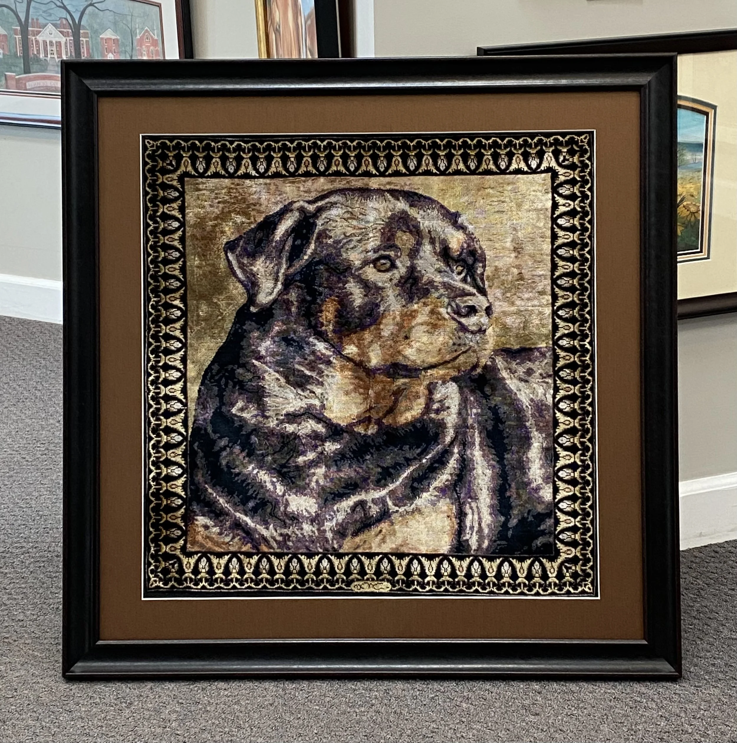 Painting of a dog with a decorative black and gold border in an art gallery.