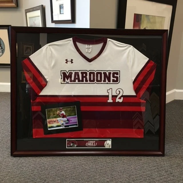 Framed sports jersey for the Maroons with the number 12, a small photo of a football player, and a nameplate reading Connor Chilli.