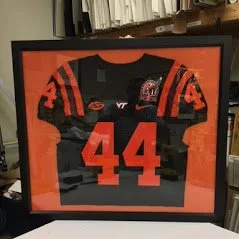 Framed sports jersey of Virginia Tech football player number 44 in a black and orange uniform.