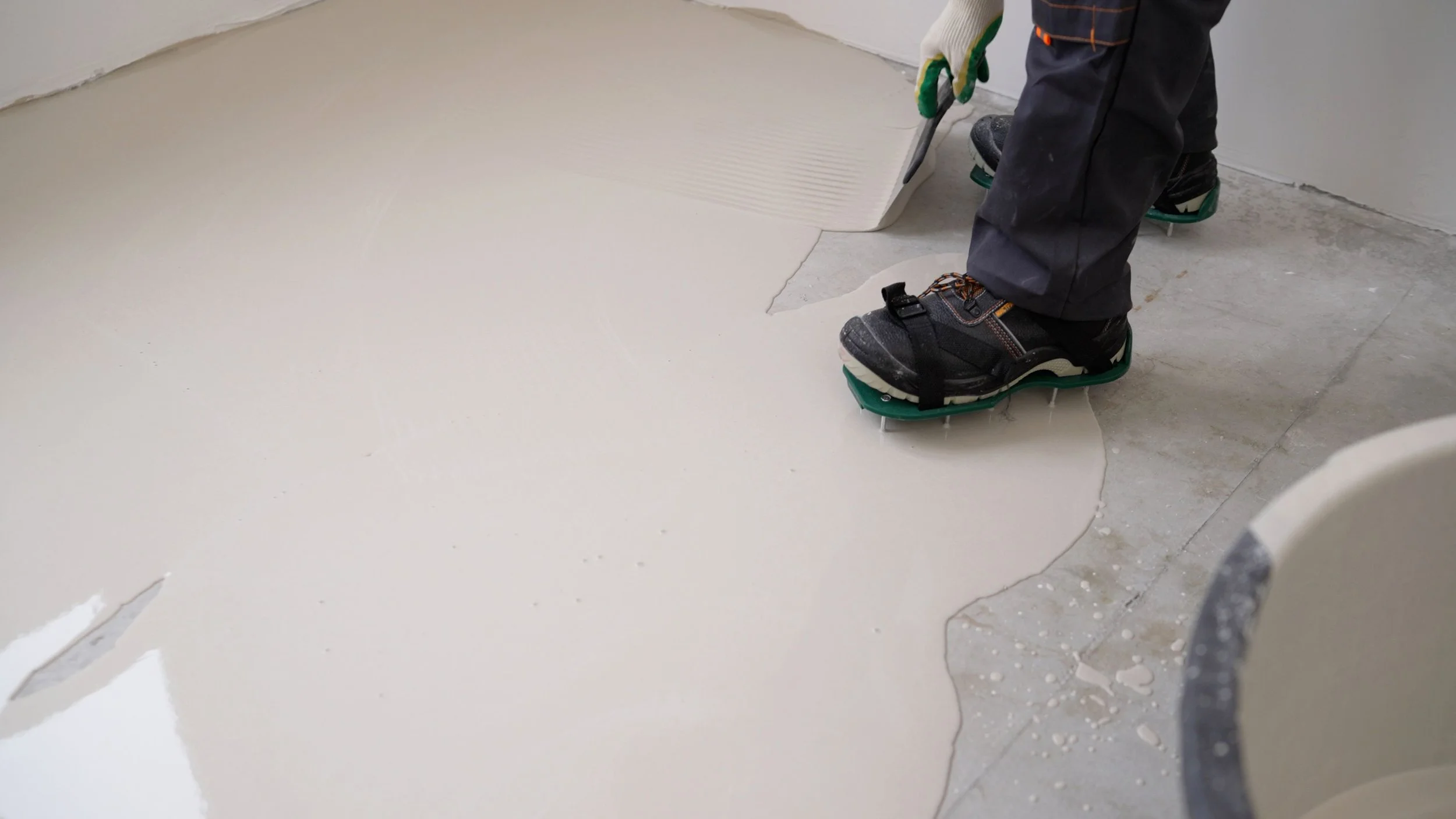 Installer spreading solid epoxy base coat on concrete surface.
