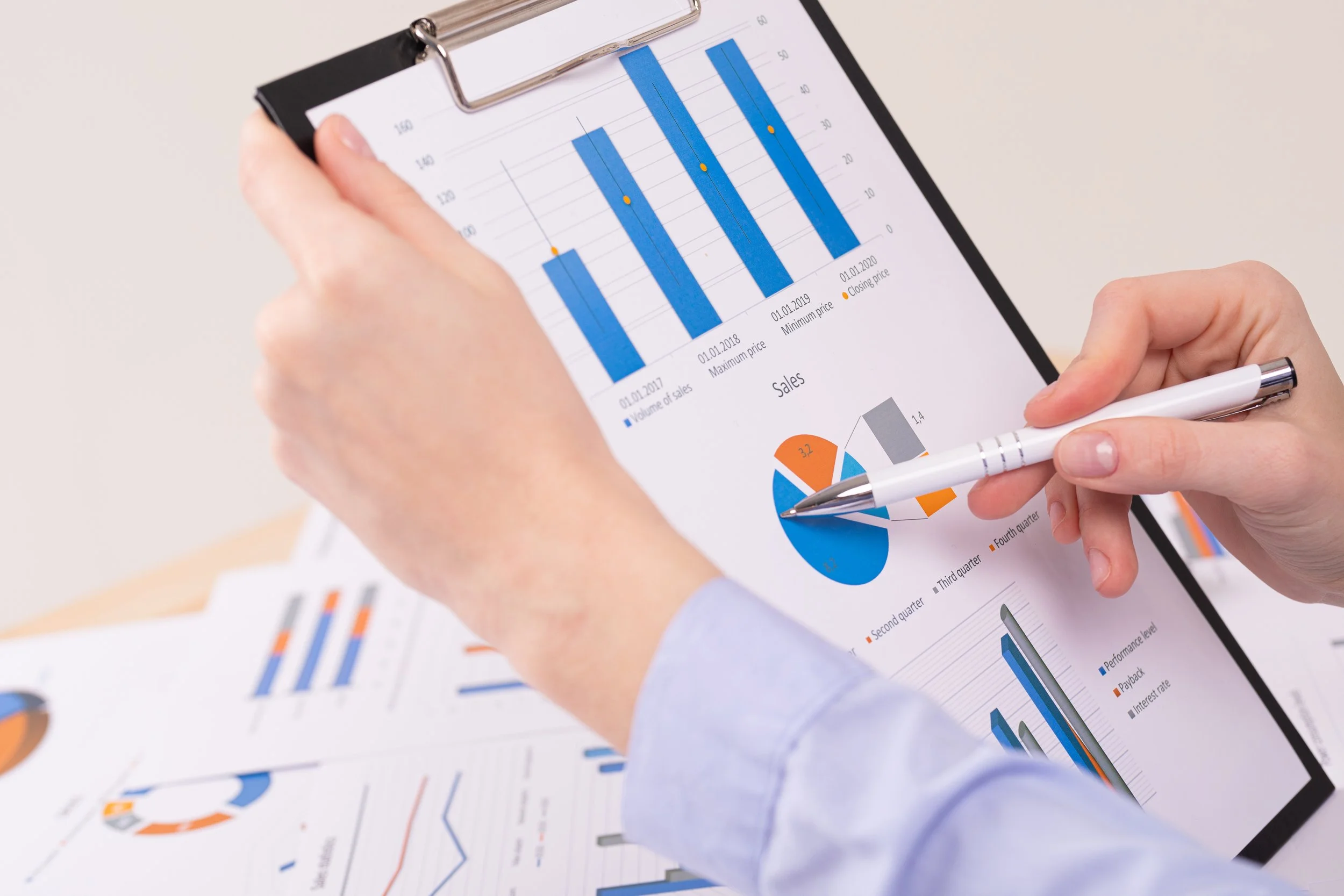 Benchmarking represented by a person analyzing charts on clipboard.