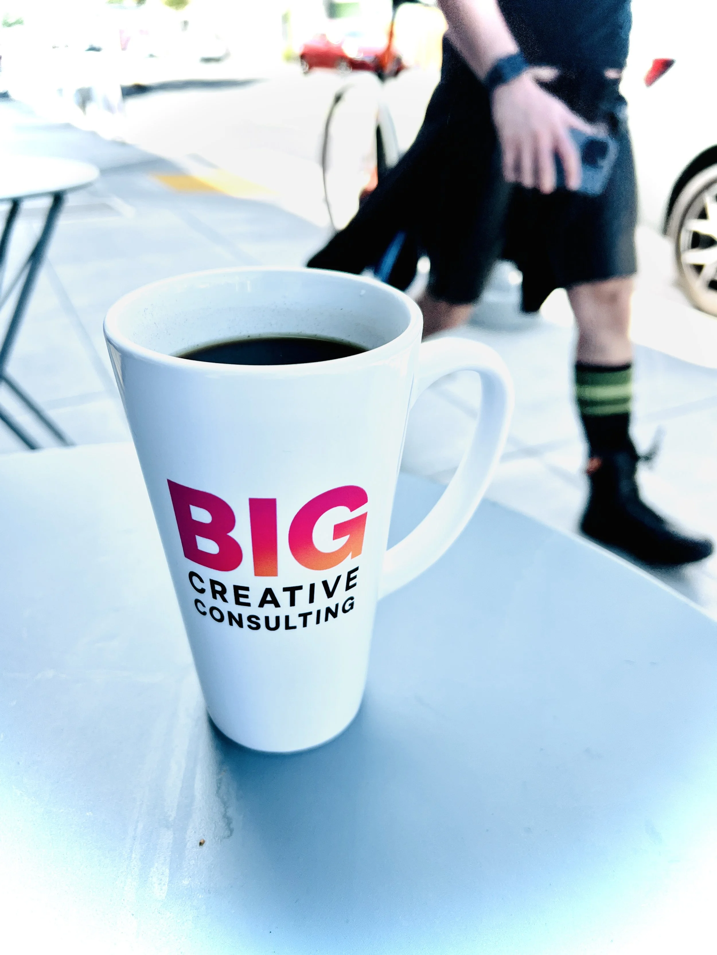 Big Creative Coffee cup on sidewalk table