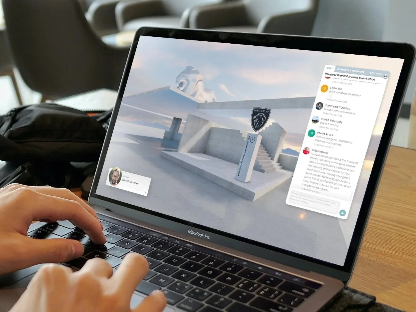 Person using a MacBook Pro to participate in an online chat, with a digital 3D model of a modern outdoor installation featuring the Peugeot logo on the screen.