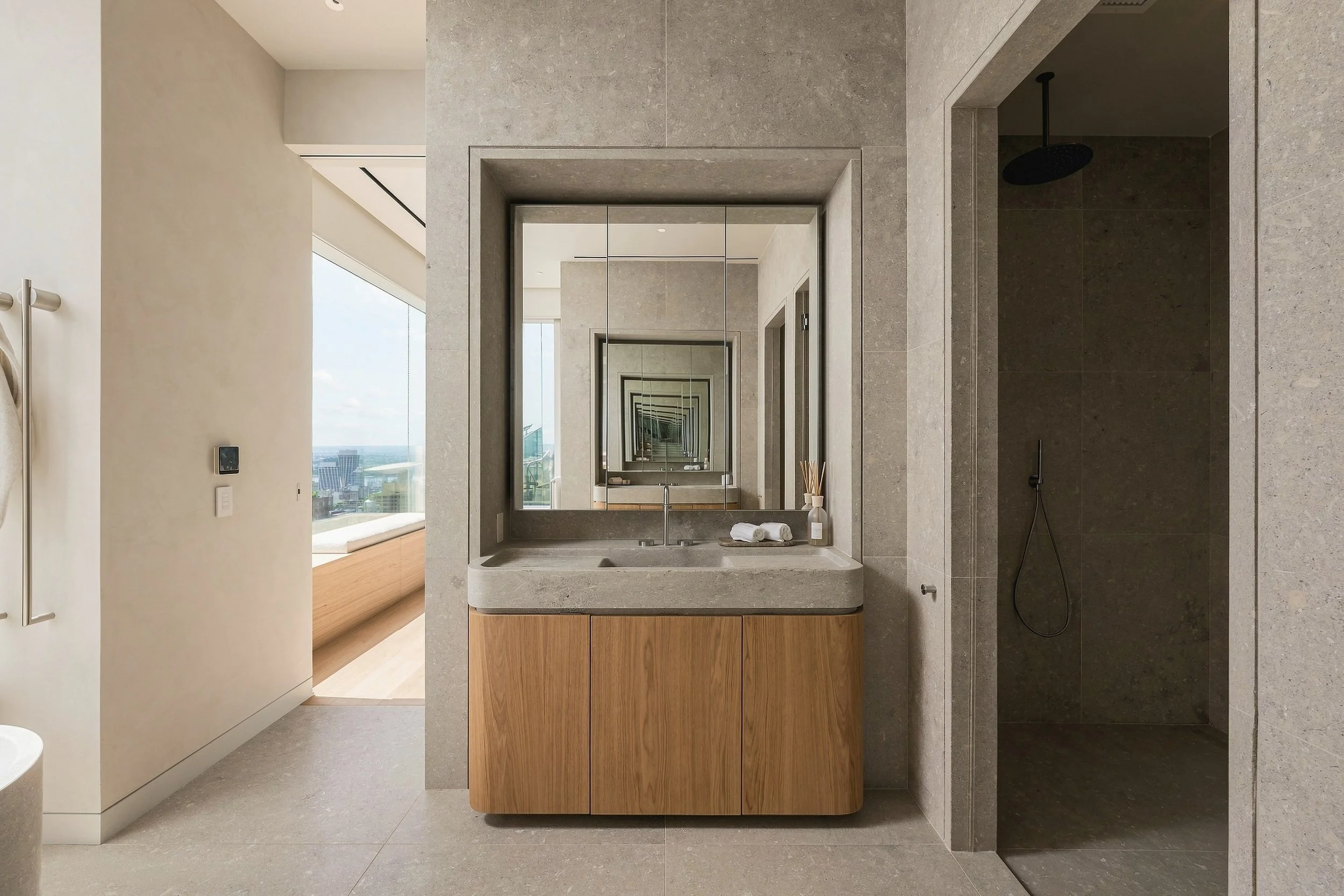 Stone and oak vanity with framed mirror in a Manhattan penthouse