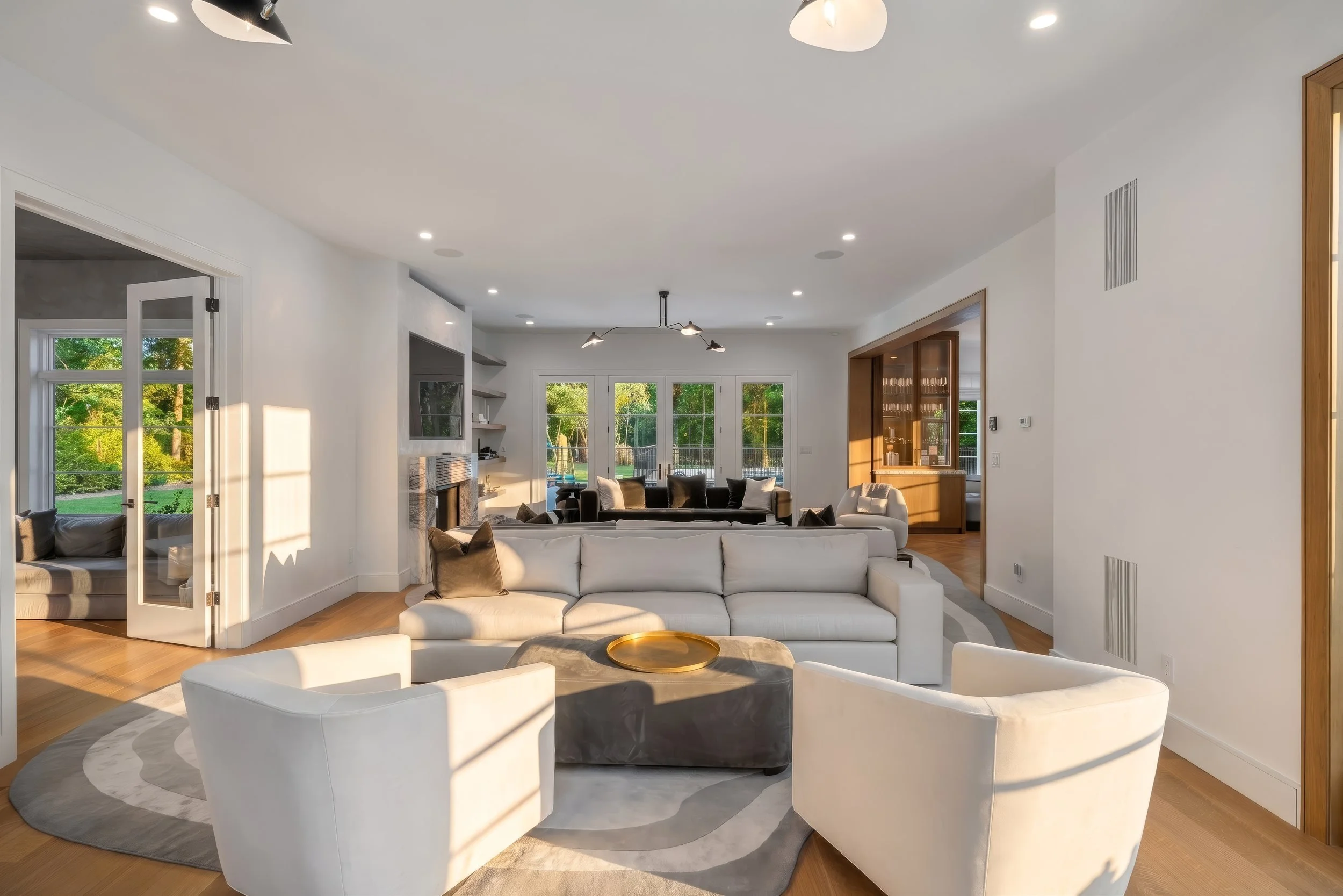 Open-plan living room with curved lounge chairs and garden doors