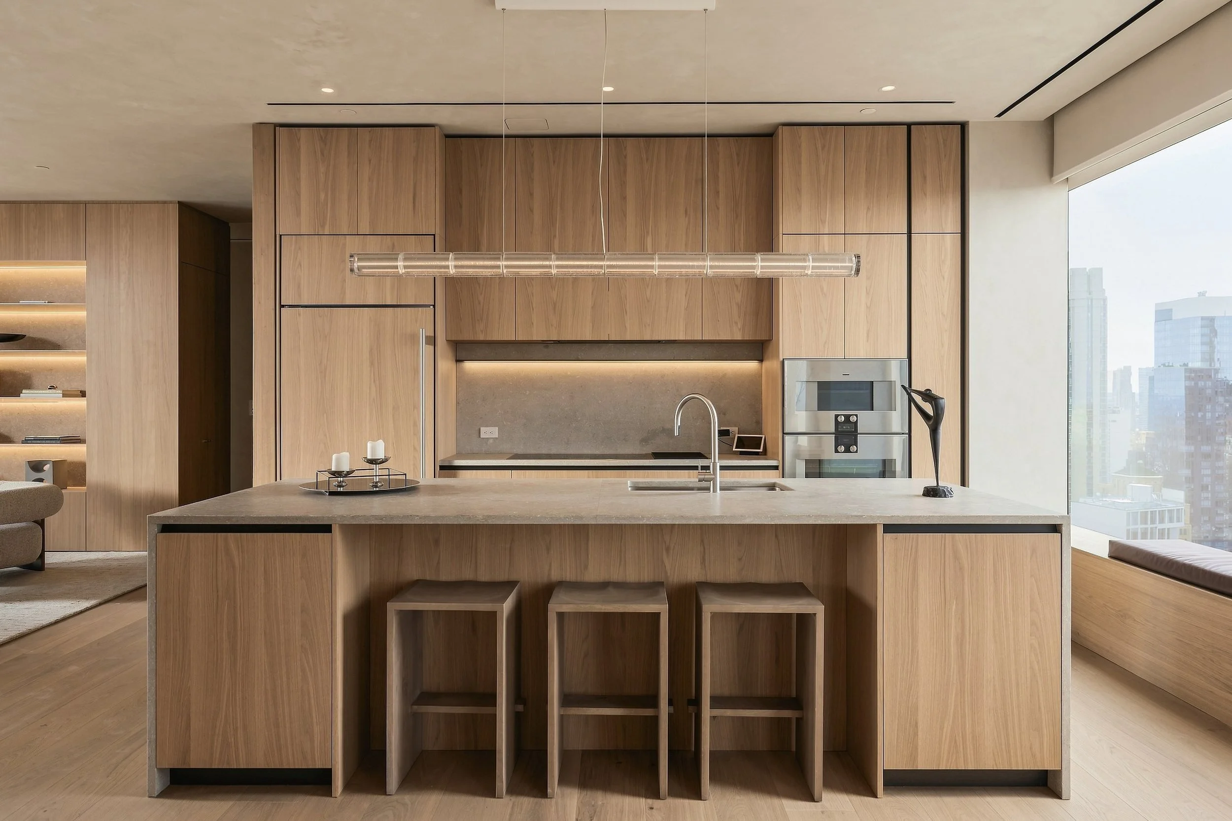 Oak kitchen with stone island and Manhattan skyline views in a penthouse, architectural interior photography by ARAZ Media